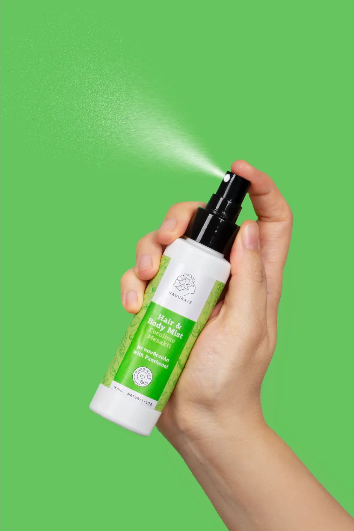 Action shot of a refreshing spray mist being sprayed by hand, featuring a fine mist spray pattern over a vibrant green backdrop