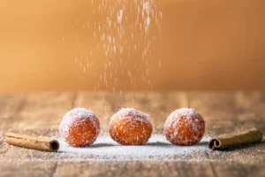 Commercial food photography - Motion shot of powdered sugar dusting over fluffy Greek donuts and cinnamon