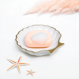 Elegant seashell soap dish with a bar of soap and rich foam, professional hero shot, bathroom decor photography